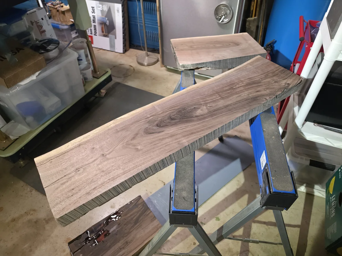Second red walnut slab process image showing surface and void work.